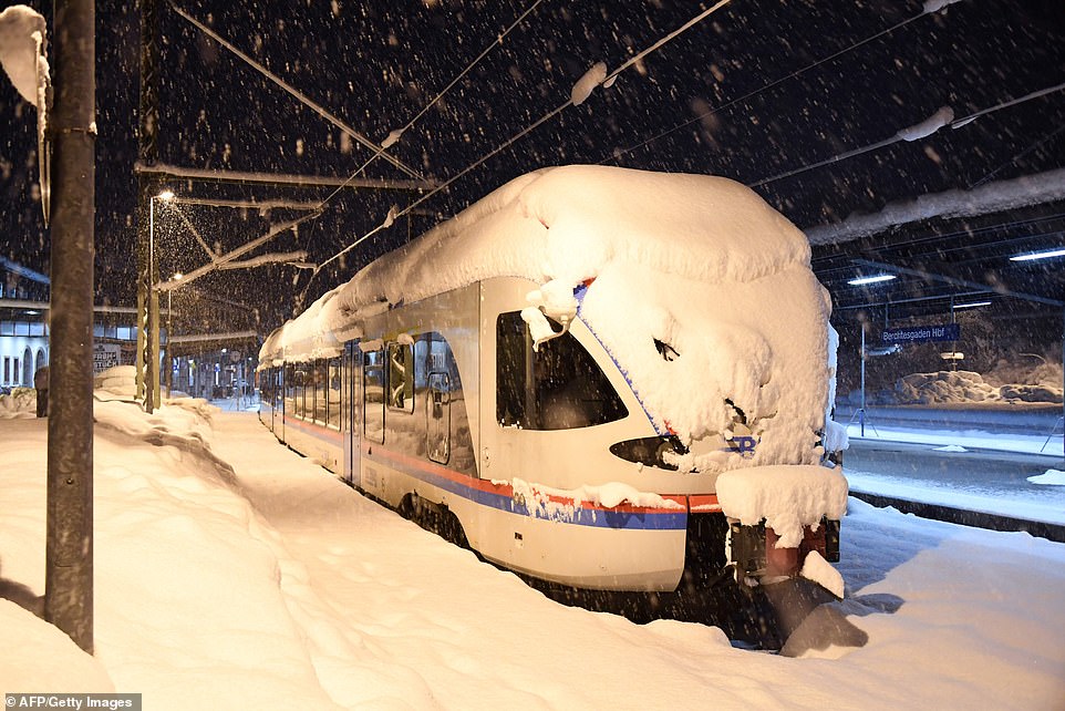 A snow covered commuter train is stuck