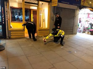 Blood splatters were being cleaned from the pavement