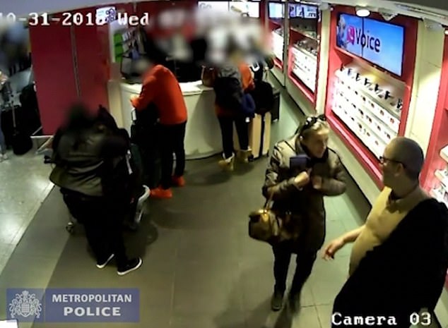 CCTV footage shows a couple laughing as they watch travellers with mountains of bags in a phone shop in Heathrow Airport